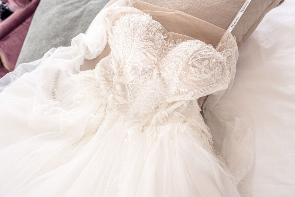 A lace wedding dress laying on the bed