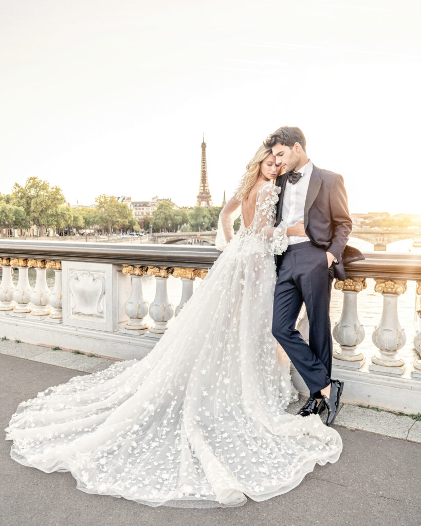Bride and groom posing on the pont alexandre III bridge in paris looking out towards the Eiffel Tower
