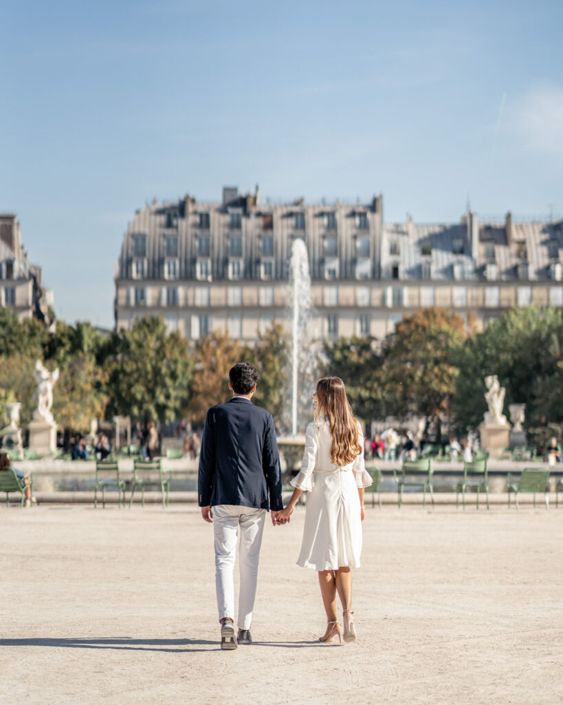 Couple walking and holding hands in the gardens of Jardin des Tuileries