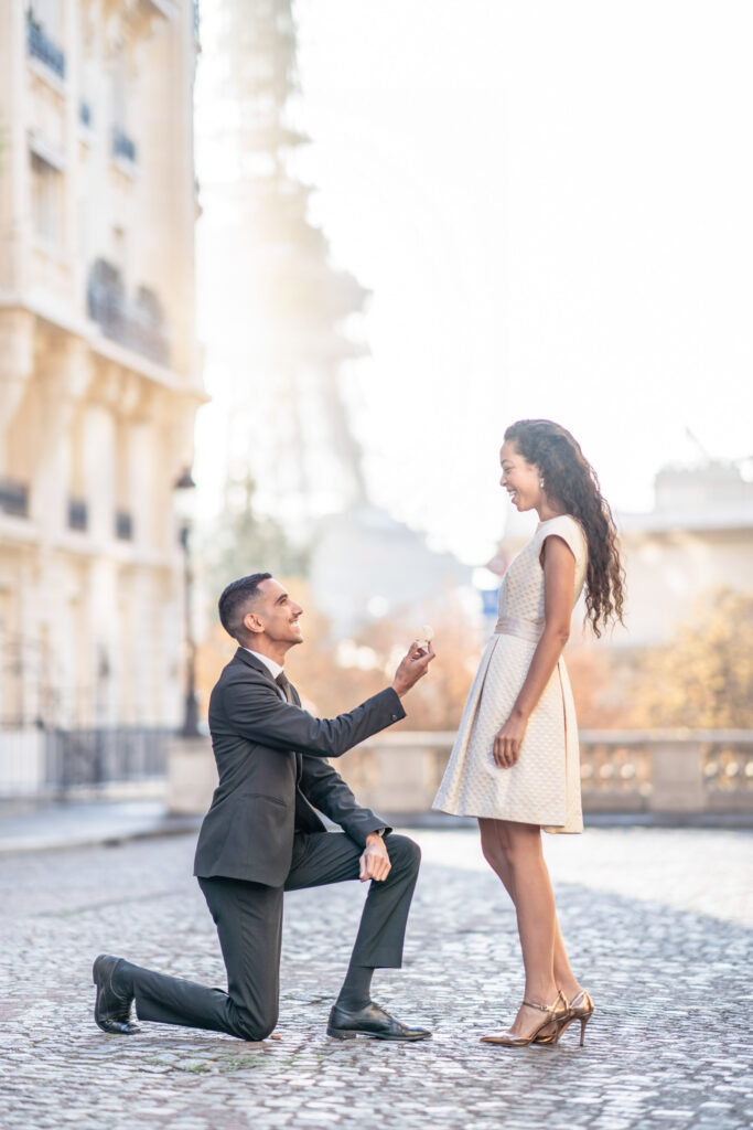 Man down on one knee proposing to his girlfriend on Avenue de Camoens with the Eiffel Tower in the background
