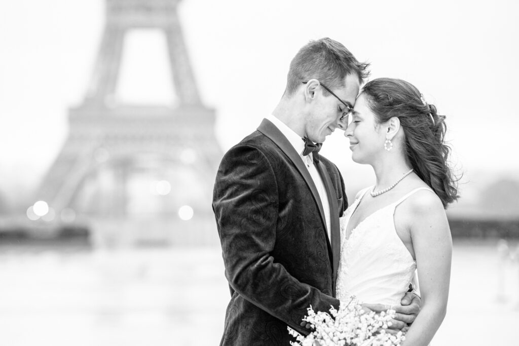 Bride and groom posing with their heads together on the Trocadero square in front of the Eiffel Tower