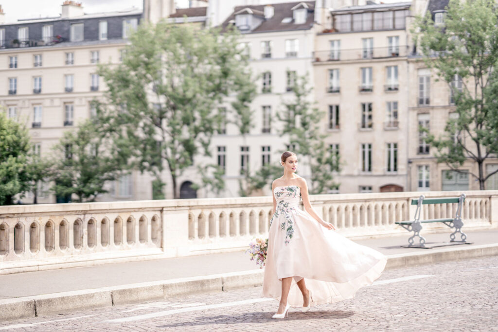 Bride walking down Pont Louis-Philippe bridge in Paris