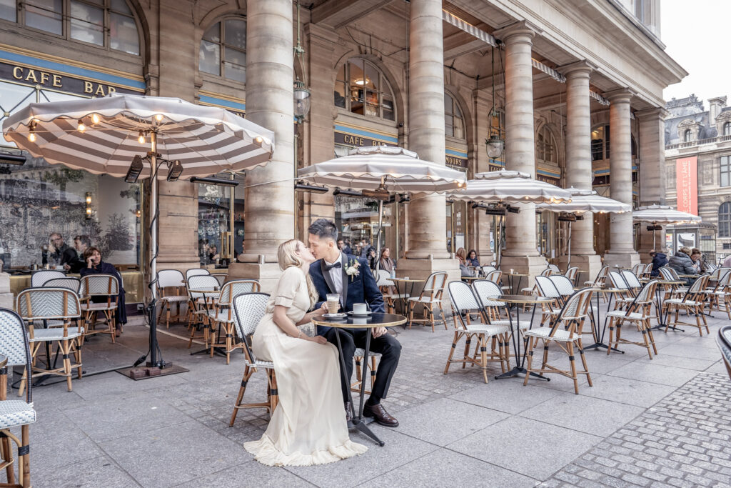Couple kissing at a table of a Paris cafe
