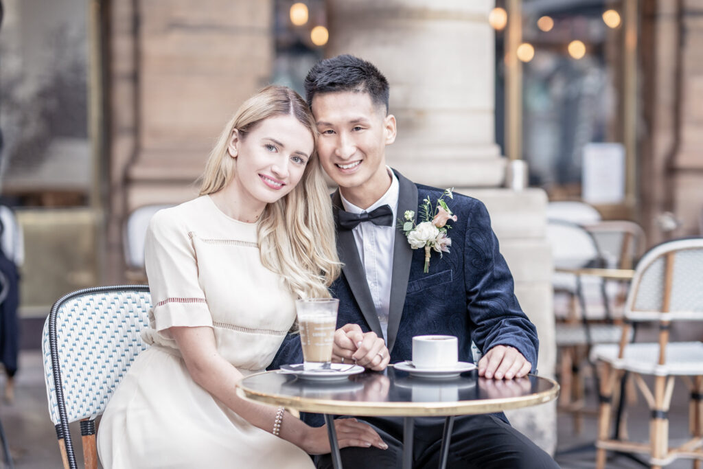 Bride and groom posing with a coffee at a Paris cafe