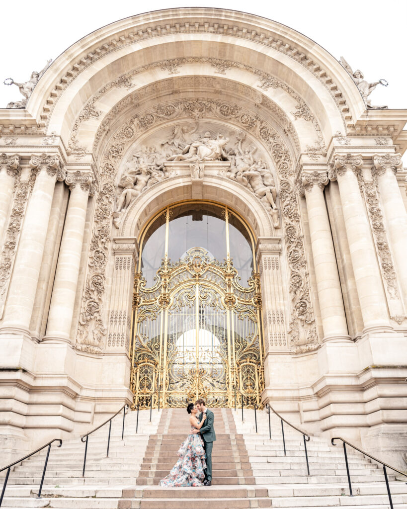 Engaged couple posing on the steps of the Petit Palais in Paris
