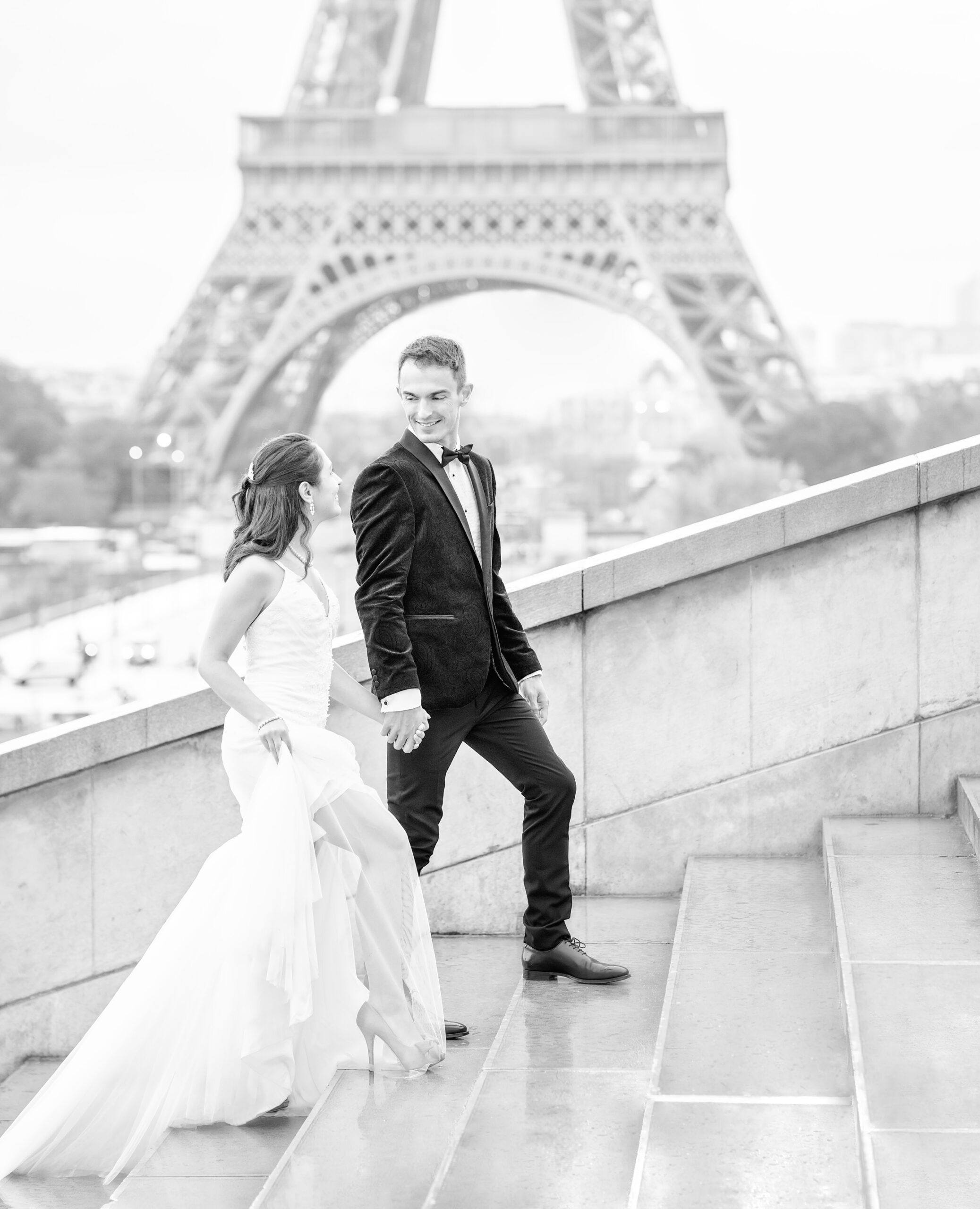 Bride and groom walking up the steps in front of the Eiffel Tower