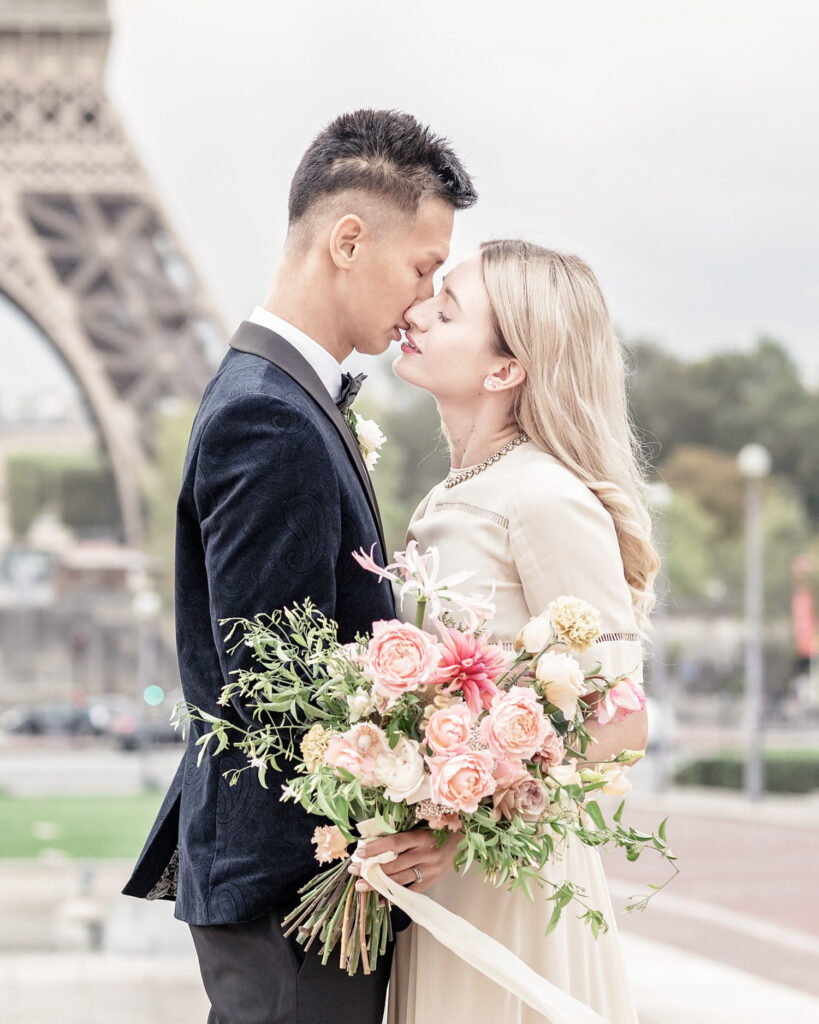 Bride and groom kissing in front of the Eiffel Tower