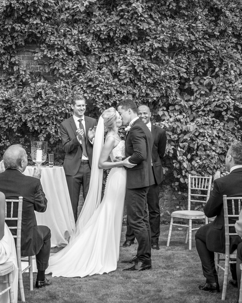 Bride and groom have their first kiss in an outside ceremony