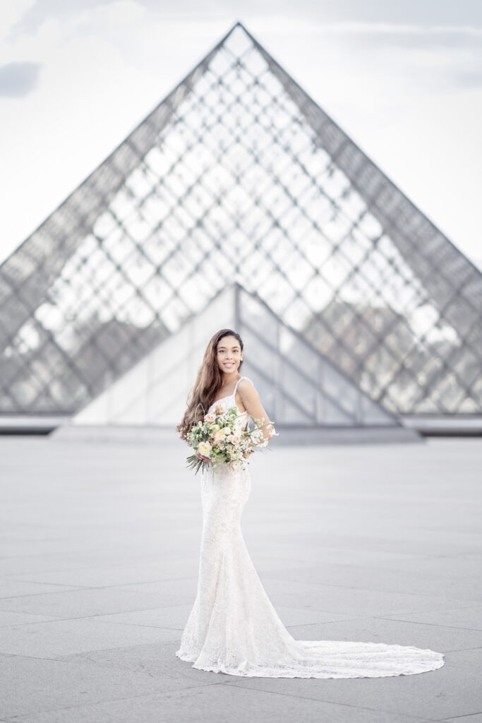 Bride Posing in front of the glass pyramid at the Louvre museum in Paris