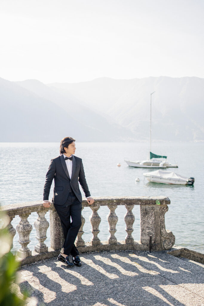 Black tie groom posing in front of lake como in Italy