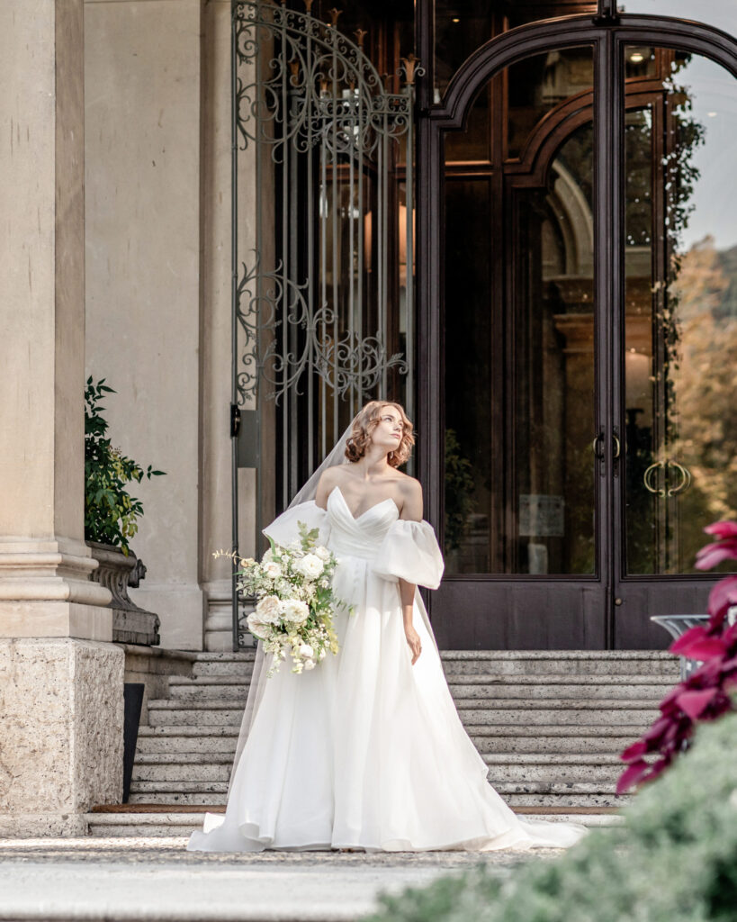 Bride posing on the stone steps leading up to the front doors at Villa Erba on Lake Como in Italy
