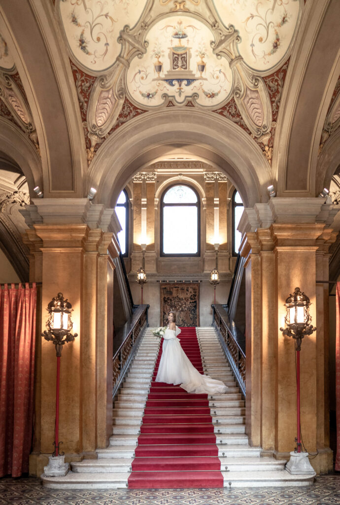 Bride posing on the grand staircase leading up to the mezzanine at Villa Erba on Lake Como in Italy