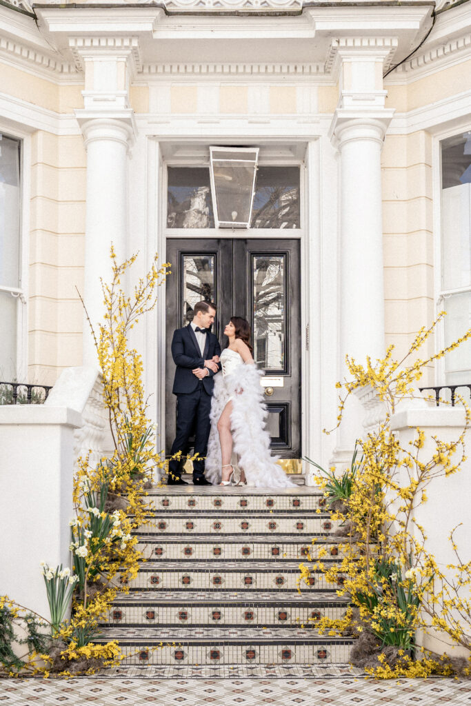 Bride and groom posing in front of a Victorian house in Kensington London