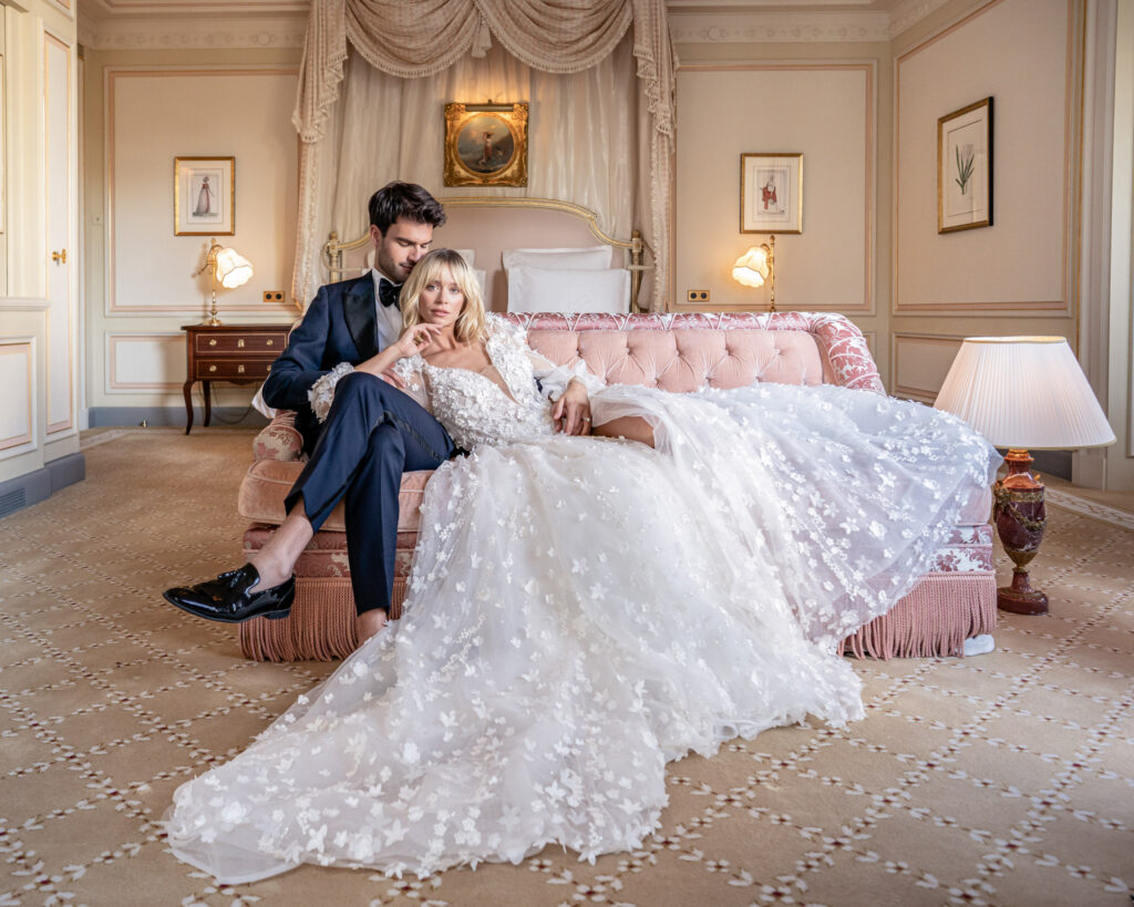 Bride and groom posing on the chaise longue in one of the suites at the Ritz hotel in Paris
