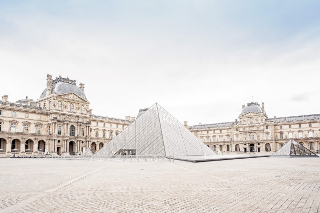 Landscape photo of the Louvre museum in Paris and it's large glass pyramid