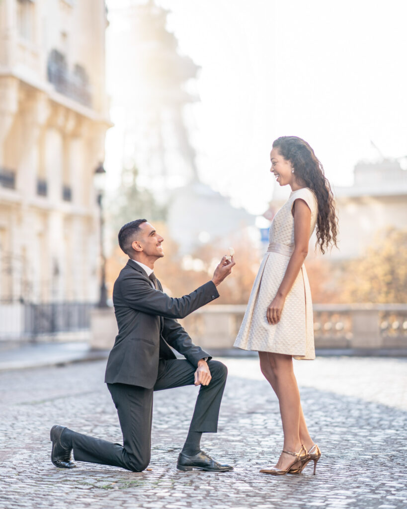 Man down on one knee and proposing to his girlfriend in front of the Eiffel Tower in Paris