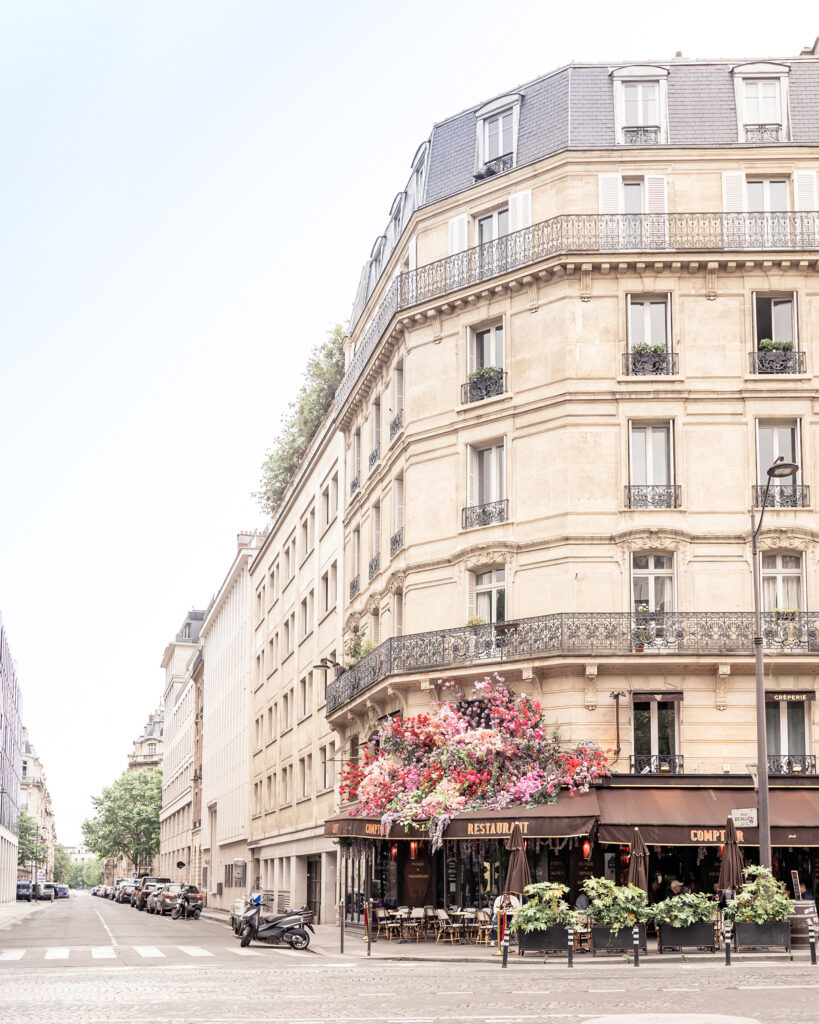 Photo of Paris buildings and typical Parisian cafe with flowers on the outside