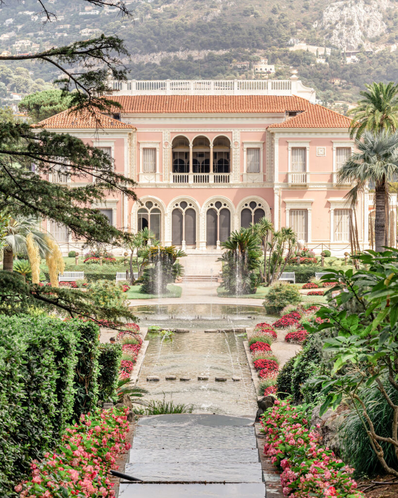 Exterior of Villa Ephrussi de Rothschild wedding venue on the French Riviera with the French garden pond and water jets in the foreground