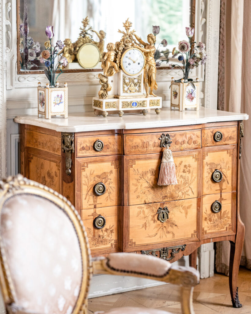 An antique bureau with vintage clock inside Villa Ephrussi de Rothschild wedding venue on the French Riviera