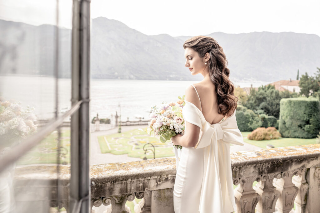 Bride on the balcony of Villa Sola Cabiati Wedding Venue looking out to Lake Como