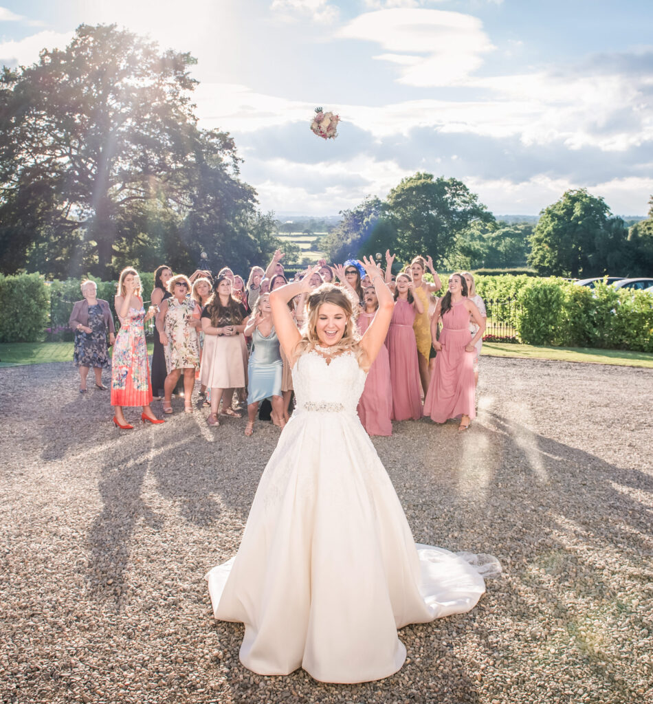Bride throwing the bridal bouquet to the wedding guests