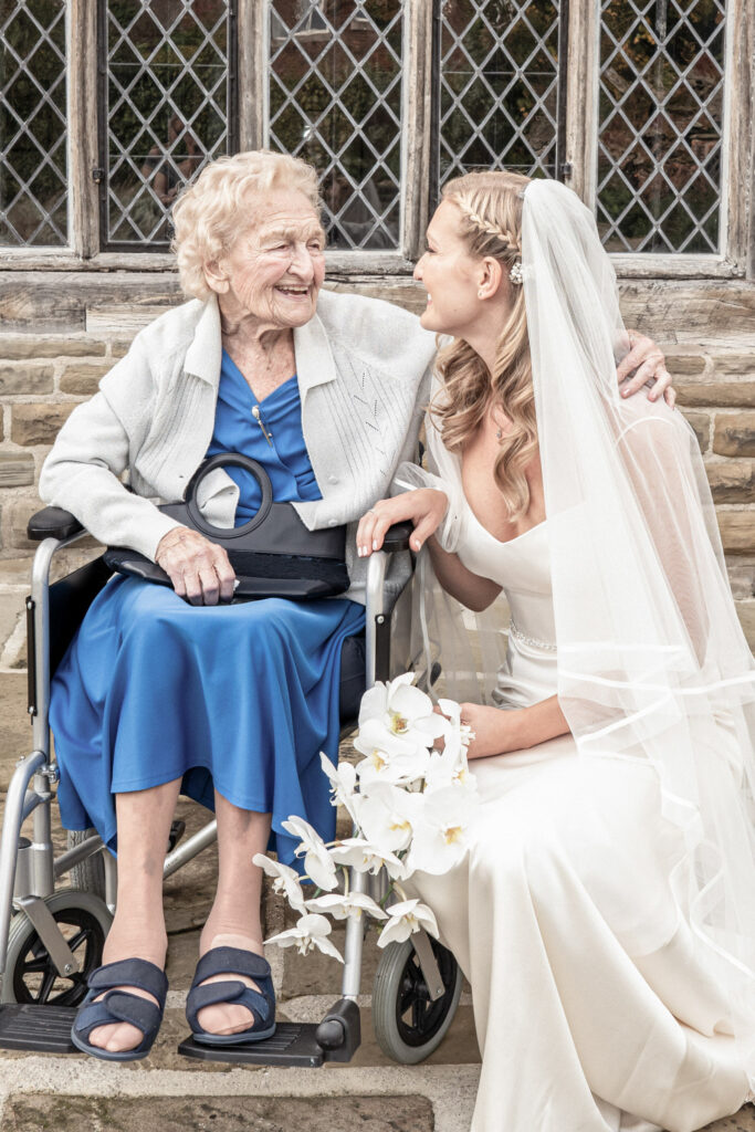 Bride and her grandmother hugging and looking at each other smiling on the day of the wedding.