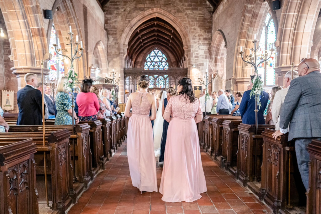 Bridal party following the bride down the aisle at a wedding in the UK