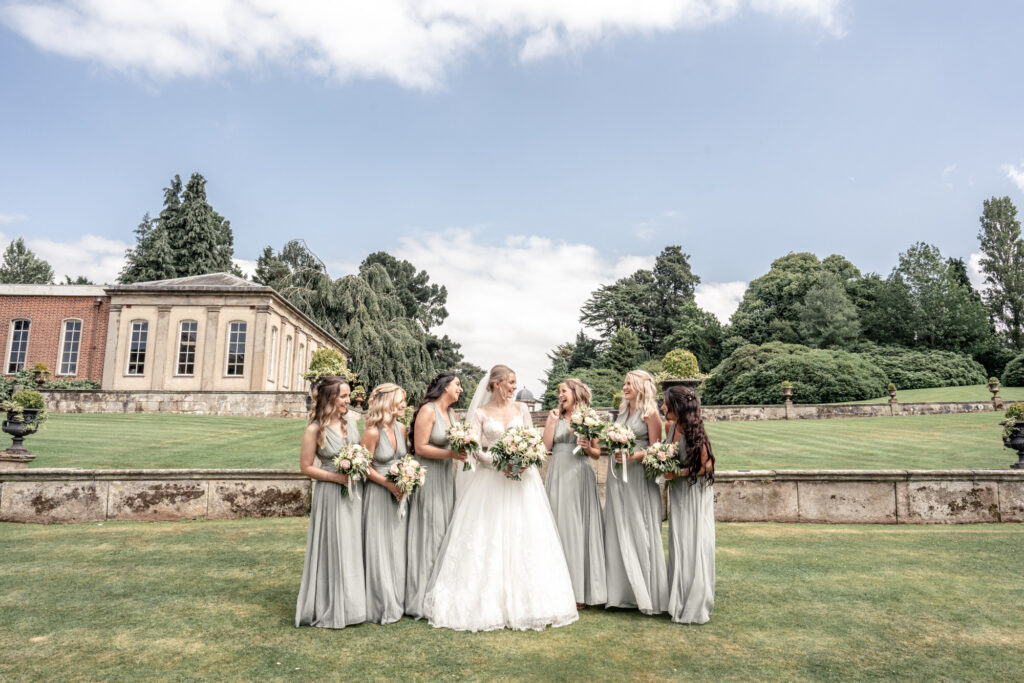 Bride laughing with her 6 bridesmaids on the formal group wedding photos