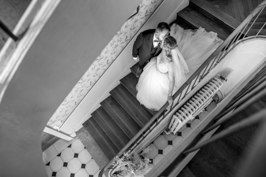 Bride and groom kissing on the steps of a French chateau.