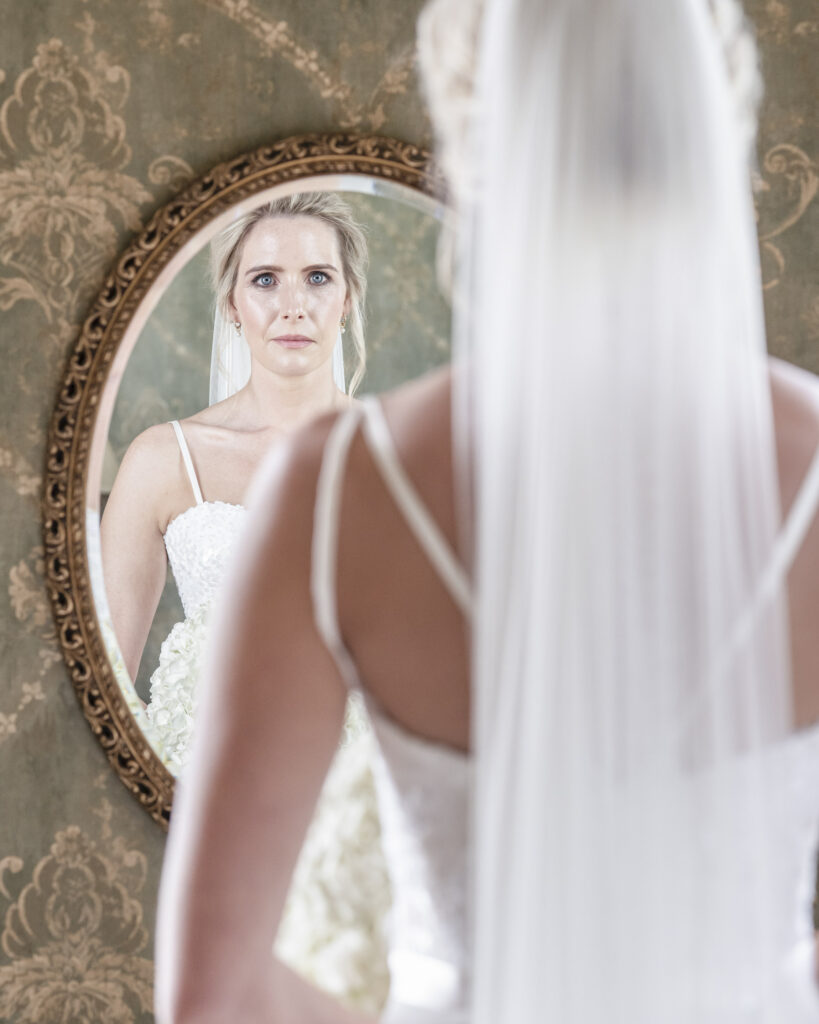 Bride looking at herself in the mirror.