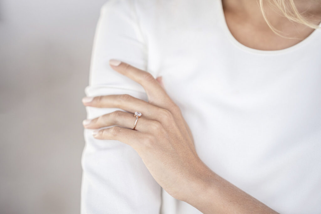 Lady showing her hand with her engagement ring on it.
