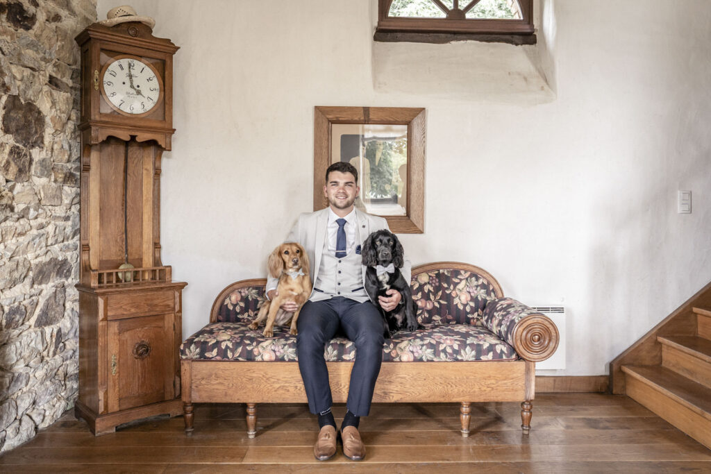 Groom sat with his dogs on his wedding day.