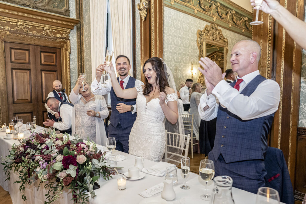 The bride and groom toasting during their speeches in the ballroom at Hawkstone Hall, Shropshire.