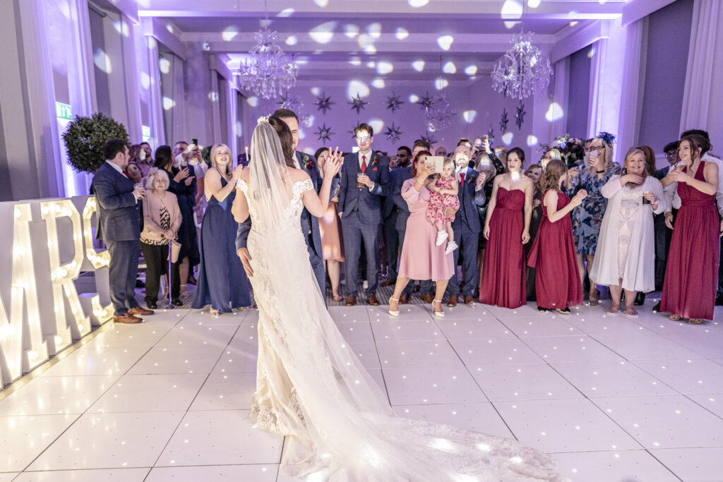 Bride and groom having their first dance on a light up dance floor in the Refectory at Hawkstone Hall wedding venue in Shropshire.