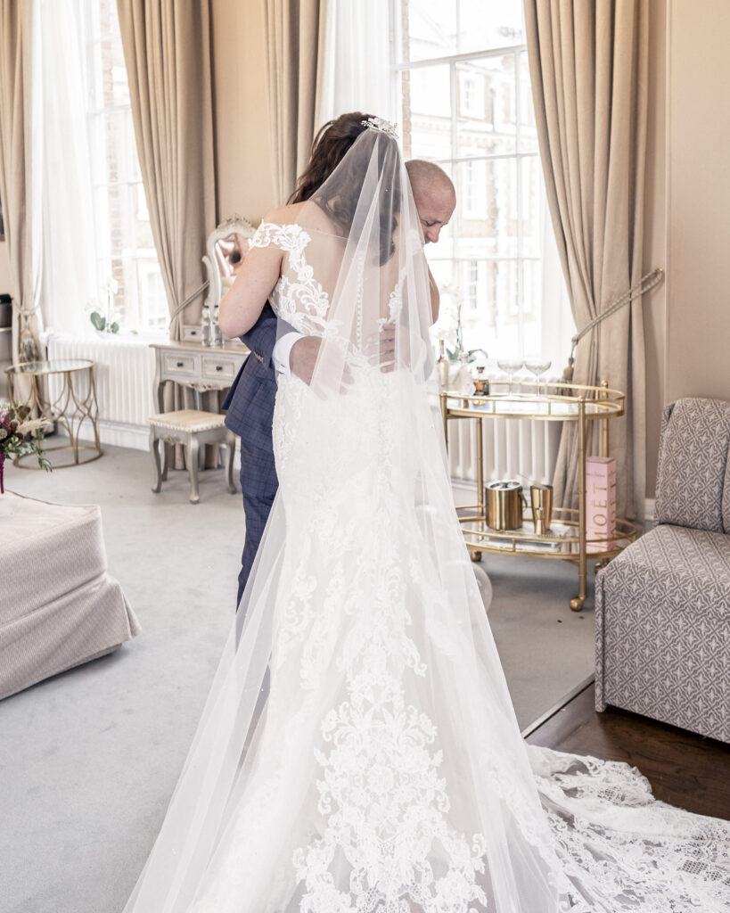Father of the bride hugging his daughter in the Bronte Suite bridal room at Hawkstone Hall wedding venue in Shropshire.