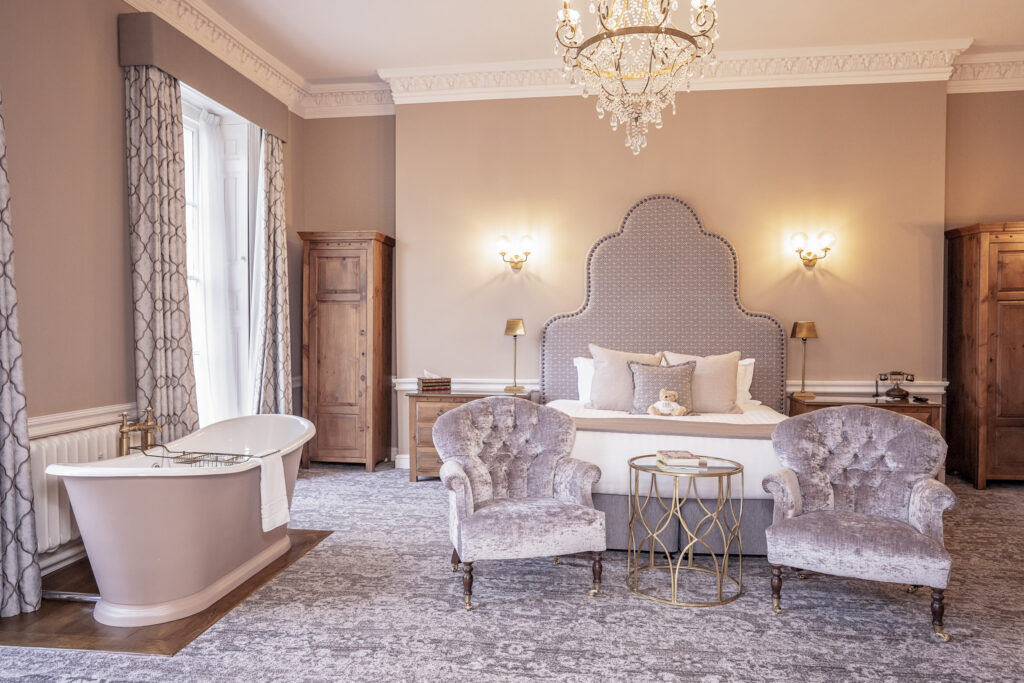 One of the guest suites with a roll top bath in the main room at Hawkstone Hall wedding venue in Shropshire.