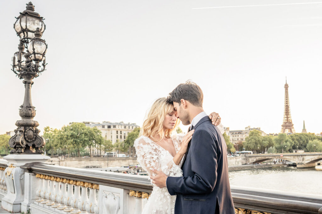 Bride and groom in a beautiful embrace on the Pont Alexandre iii bridge in front of the Eiffel Tower in Paris.
