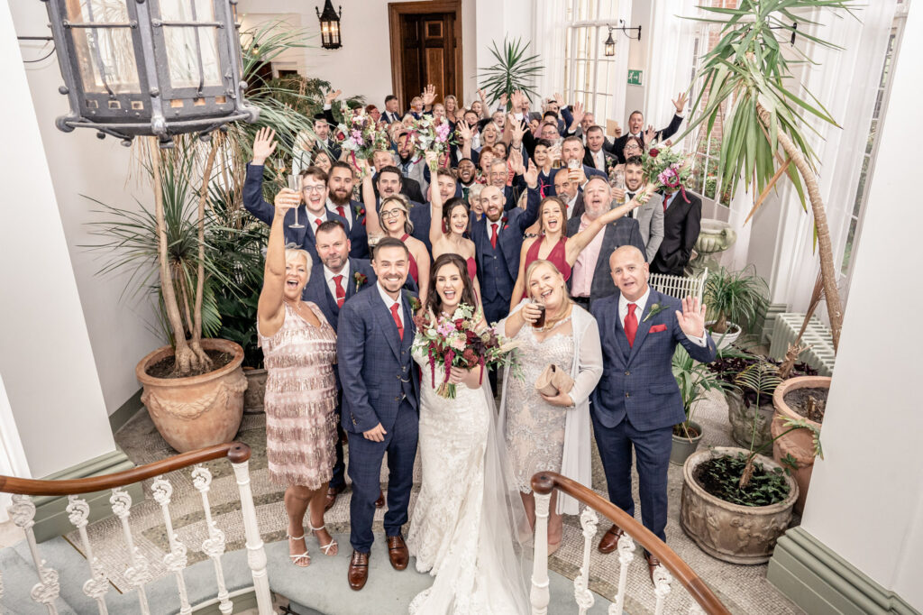 Large group wedding photo in the Winter garden room at Hawkstone Hall in Shropshire