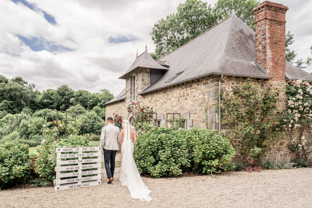 A bride and groom walking hand in hand after just getting married at Chateau du Grand Val in France.