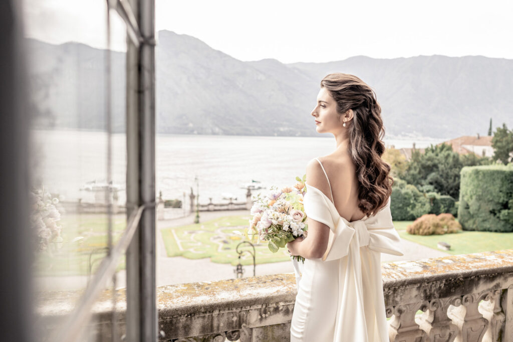 A bride on the balcony of Villa Sola Cabiati overlooking Lake Como in Italy.