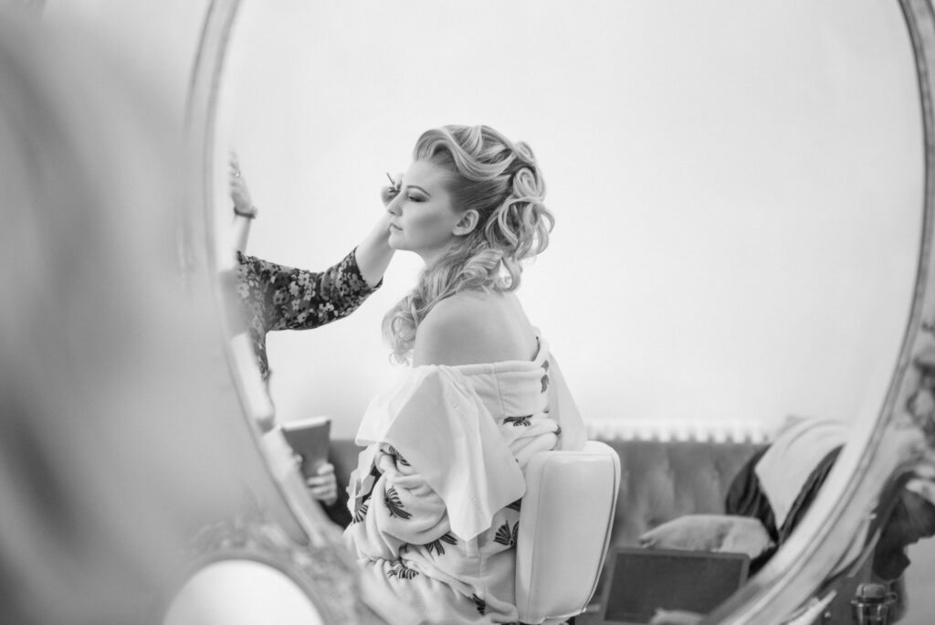 Bride having her hair and make up done in the dressing room at Tyn Dwr Hall.