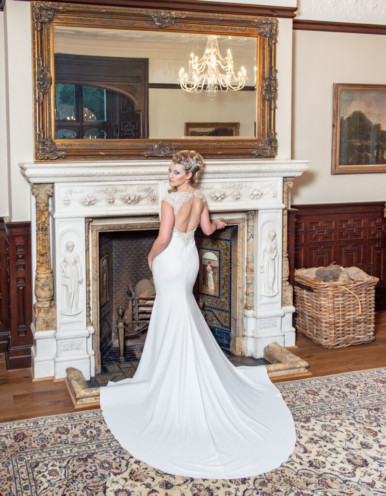 Bride posing by the fireplace at Tyn Dwr Hall wedding venue.